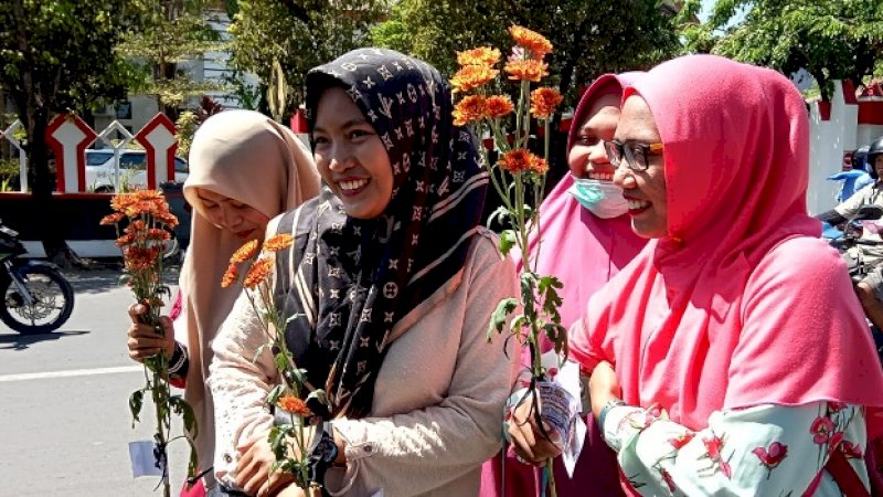Puluhan polisi wanita (polwan) dari Polres Gowa bagi-bagi bunga kepada pengendara yang melintas di depan kantor DPRD Gowa, Jalan Masjid Raya, Kamis (12/9/2019).
