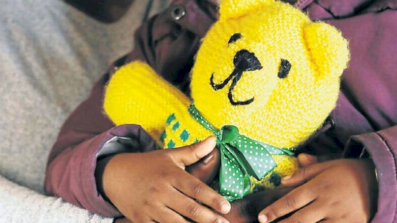 Balita itu memegang boneka Teddy Bear (Daily Mirror)