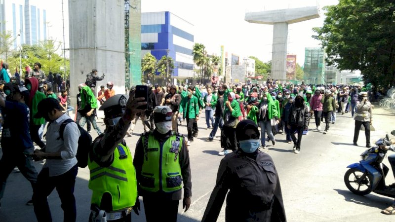 Polisi saat selfi di tengah aksi unjuk rasa di Makassar, Kamis (26/9/2019).