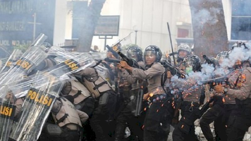 Petugas kepolisian menembakkan gas air mata untuk menghalau pengunjuk rasa.
