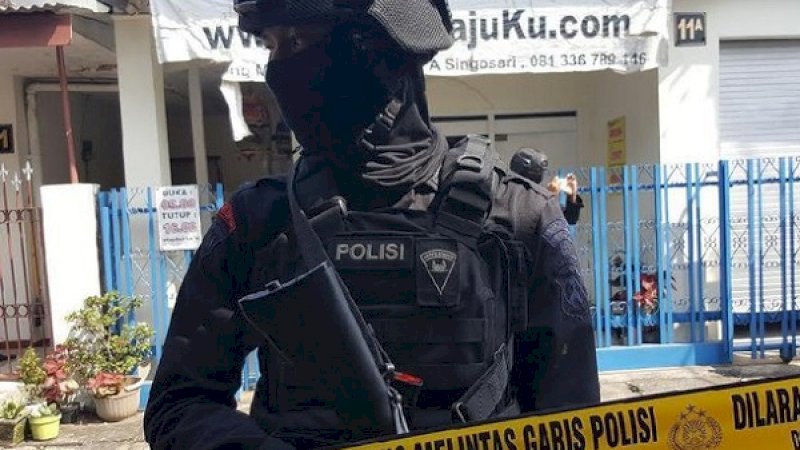 Seorang anggota Densus 88 Antiteror Polri, berjaga-jaga di dalam areal garis polisi yang dipasang di rumah kontrakan seorang terduga teroris di Cengkareng, Jakbar.