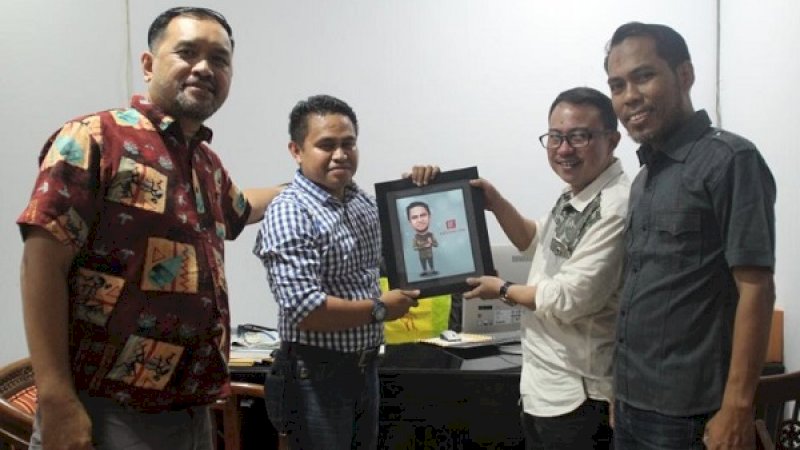 Dirut Rakyatku.com, M Subhan Yusuf (kedua dari kanan), menyerahkan karikatur kepada Ketua KPU Kota Makassar, Farid Wajdi, didampingi Komisioner KPU Kota Makassar Bidang Teknis, Gunawan Mashar. (Foto: Arfa Ramlan/Rakyatku.com)