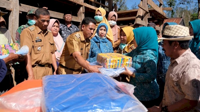 Wakil Ketua TP PKK Gowa memberikan bantuan kepada pengungsi karhutla.