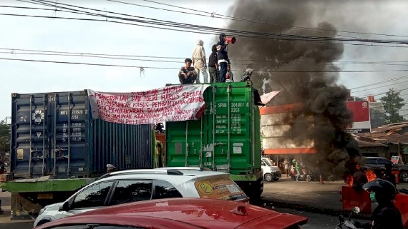 Mahasiswa membakar ban bekas dan memalang tiga buah truk di perbatasan Makassar-Gowa.