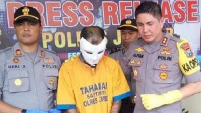 Rendi Setiawan (memakai topeng) saat diamankan di Mapolres Jember.