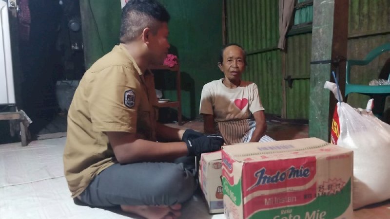 Seorang pekerja sosial, memberikan bantuan mi instan dan beras kepada Indo Upo, nenek 71 tahun yang tinggal sebatangkara di Pangkep.