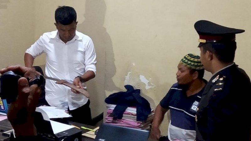 Pelaku yang penggal kepala keponakannya di Gowa, Haji Saju (kedua dari kiri), memperhatikan parang di tangan penyidik. Parang itu dipakai memenggal kepala Daeng Sampara.