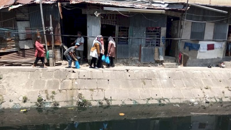 Tim Andalan Mengaji, menyerahkan bantuan sembako kepada warga pinggiran kanal di Jalan Sungai Saddang, Makassar.