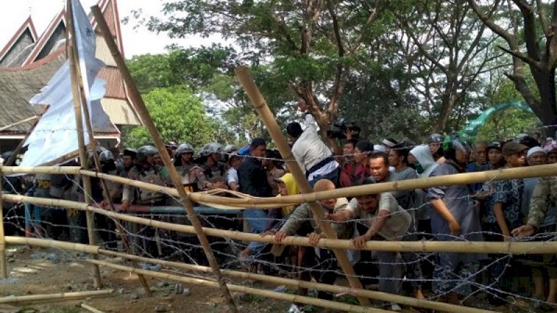 Warga bersama Satpol PP, membongkar pagar yang membatasi lahan di Pannara yang kerap dijadikan lapangan sepakbola oleh warga setempat.