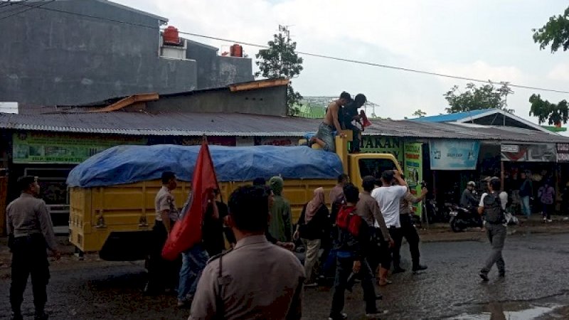 Pengunjuk rasa menahan truk di perbatasan Makassar-Gowa, namun sempat digagalkan aparat kepolisian.