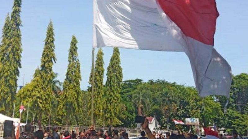 Pengibaran bendera merah putih raksasa di depan Monumen Mandala, Minggu, 1 Desember 2019.