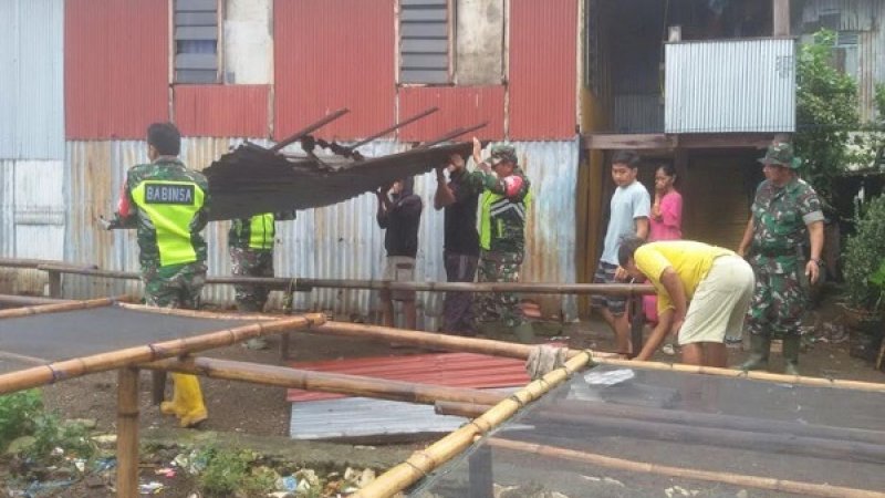 Pasca diterjang angin kencang, warga dibantu petugas keamanan mulai memperbaiki rumahnya yang rusak, Senin (6/1/2019).