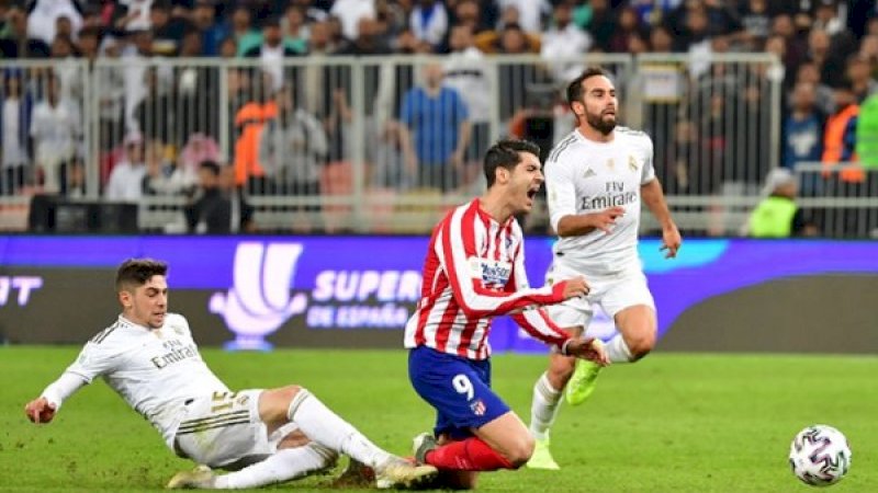 Momen saat Federico Valverde menjatuhkan striker Atletico Madrid, Alvaro Morata, pada laga final Piala Super Spanyol di Stadion King Abdullah, Jeddah, Senin dini hari Wita (13/1/2020). (Foto: AFP)