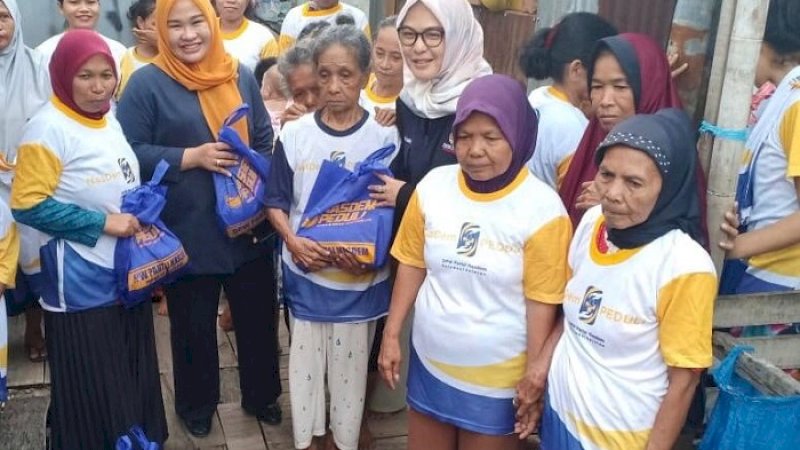 Partai Nasdem bagi-bagi bahan pokok kepada warga.