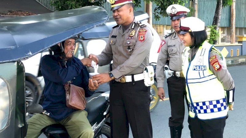 Kanit Regident Polres Wajo, Iptu Jumadi memberikan sarapan pagi pada tukang becak motor di Sengkang, Jumat (24/1/2020).