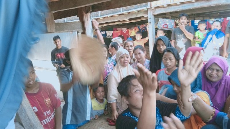 Ati, istri Sina, menangis histeris saat melihat jasad suaminya digotong warga.