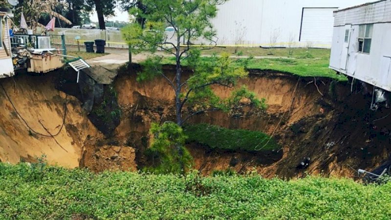 Lubang menganga yang membuat satu unit terkubur.