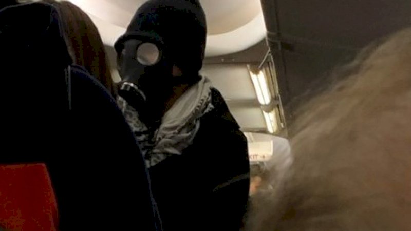 Pria bertopeng yang diturunkan dari pesawat American Airlines.