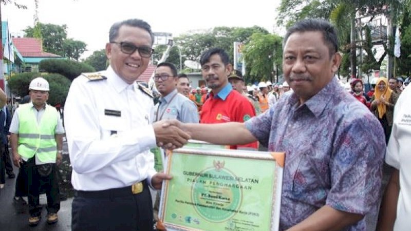 Gubernur Sulawesi Selatan, Nurdin Abdullah (kiri), memberikan Sertifikat Penghargaan kepada PT Bumi Karsa atas kinerja sebagai Panitia Pembina Keselamatan dan Kesehatan Kerja (P2K3) diwakili oleh Kamaluddin, selaku Direktur Utama PT. Bumi Karsa.
