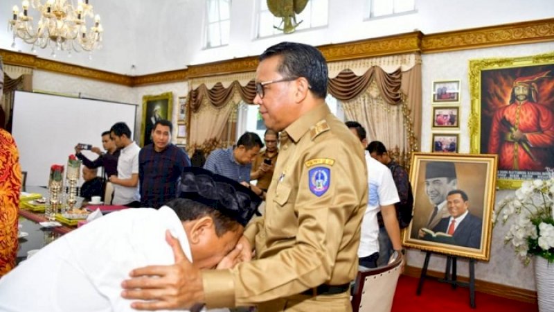 Mantan Kadis PUPR, mencium tangan Gubernur Sulsel, Nurdin Abdullah, Selasa (24/2/2020).