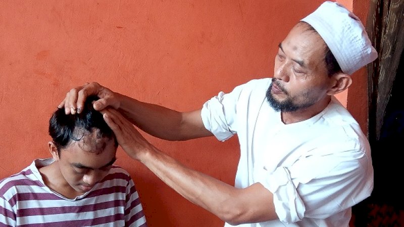 Ayah korban, Irwan Tompo memperlihatkan luka di kepala anaknya usai dikeroyok.