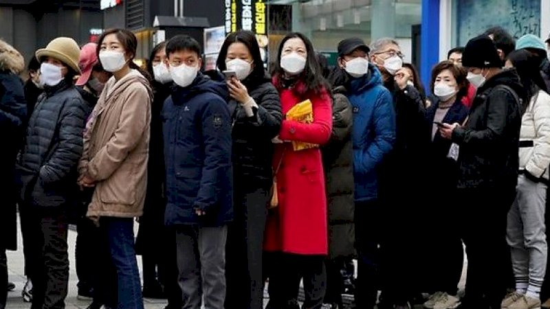 Orang-orang yang memakai masker mengantre untuk membeli masker di depan sebuah department store di Seoul, Korea Selatan, 28 Februari 2020. (Reuters)