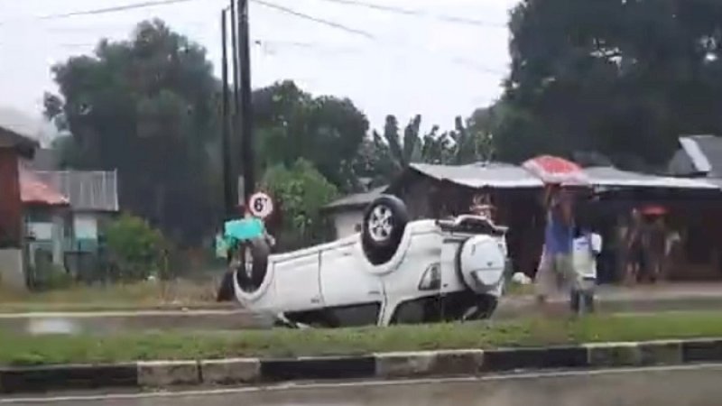Sebuah minibus putih terguling di jalan poros Barru, Trans Sulawesi. 