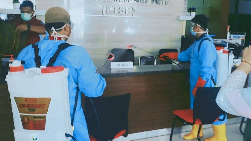 Dua petugas menyemprot ruangan di kantor Kejaksaan Negeri Jeneponto, Kamis (19/3/2020). 