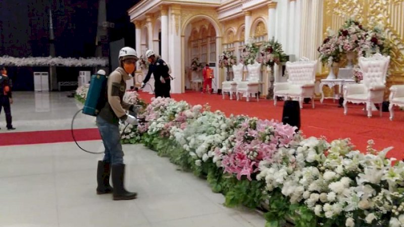 Petugas menyemprot lokasi resepsi pernikahan anak Wakil Wali Kota Samarinda, Muhammad Barkati. 