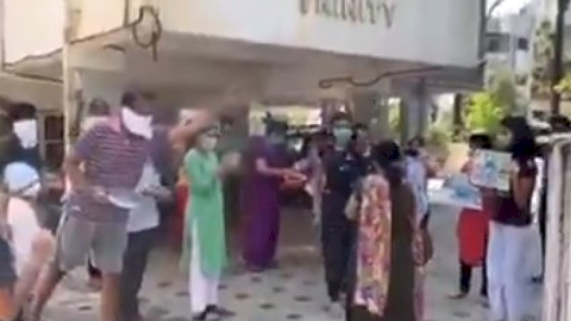 Seorang dokter yang pulang dari rumah sakit setelah 20 hari bertugas disambut tetangga dan keluarganya.