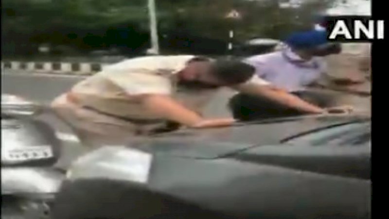 Polisi akhirnya menghentikan mobil yang menyeret rekannya. 