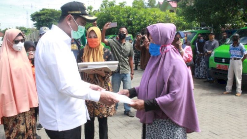 Bupati Barru, Suardi Saleh menyerahkan bantuan kepada warga terdampak virus corona.