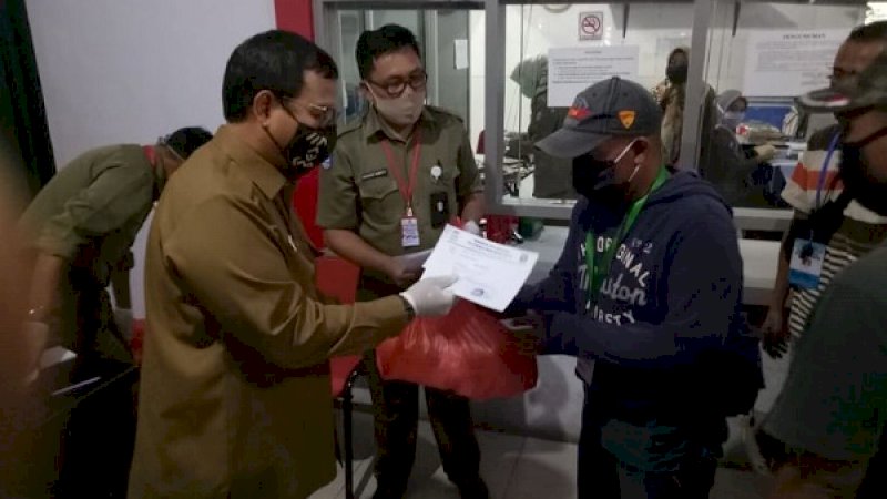 Pj Wali Kota Makassar, Iqbal Suhaeb, menyerahkan bantuan sembako untuk juru parkir (jukir) se-Kota Makassar.