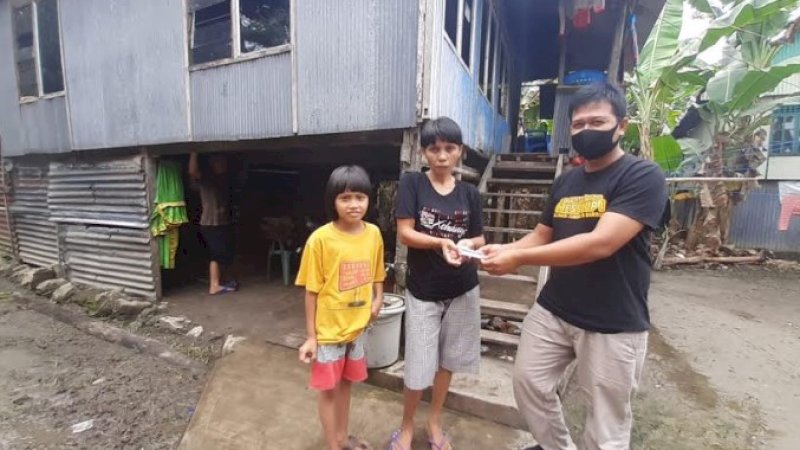 Ketua AJB, Ahmadi Kalub menyerahkan bantuan kepada Dewi, janda jurnalis senior yang luput bantuan pemerintah.