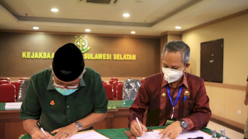 FOTO:Kajati Sulsel, Firdaus Dwilmar dan Pj Wali Kota Makassar, Prof Yusran Yusuf tanda tangan MoU  pengamanan aset di pulau milik Pemkot Makassar, KAMIS,(28/5).