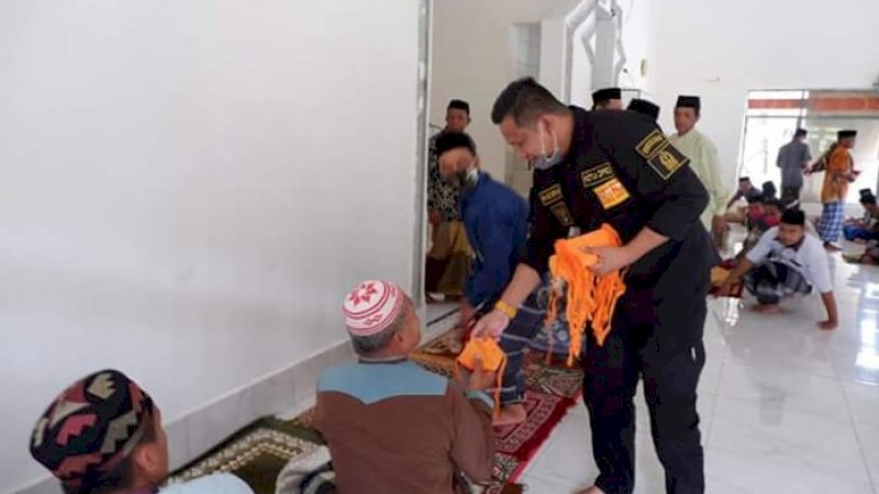 Ketua DPRD Bone, Irwandi Burhan membagi-bagikan masker kepada jemaah salat Jumat (19/6/2020).