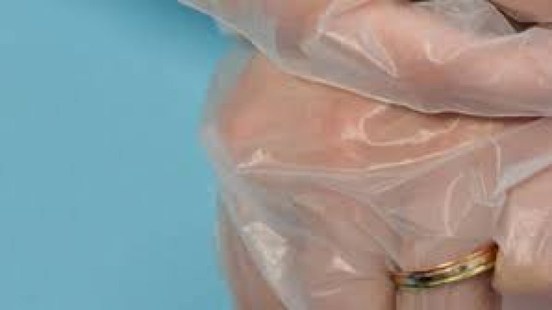 Pemasangan cincin kawin pun di luar sarung tangan plastik. 