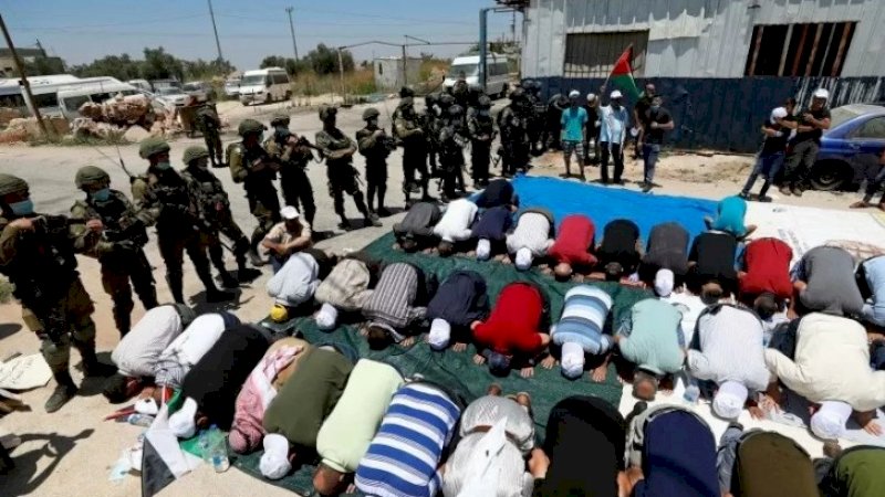 Warga Palestina melaksanakan salat Jumat di Tepi Barat. (FOTO: REUTERS)