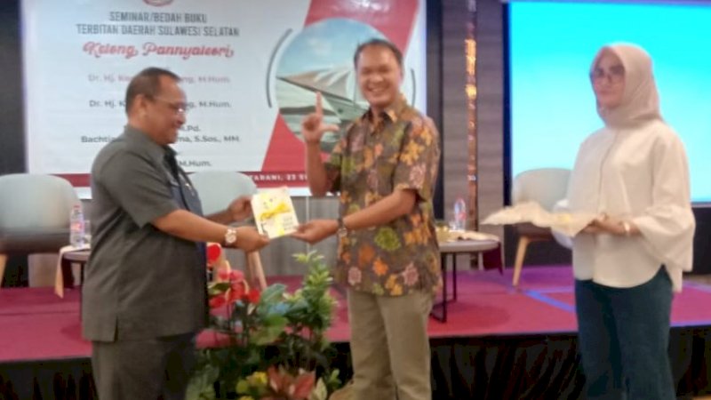 Rusdin Tompo menyerahkan buku kumpulan puisi terbarunya berjudul "Kata Sebagai Senjata" kepada Kepala Dinas Perpustakaan dan Kearsipan (DPK) Provinsi Sulawesi Selatan, Mohammad Hasan, Rabu (23/9/2020).