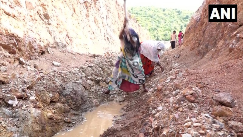 Perempuan India membelah bukit demi mengalirkan air ke kampung mereka. (FOTO: ANI)