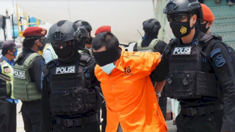 Dengan pengawalan ketat oleh tim Densus 88 Antiteror Polri, terduga teroris dirantai lengkap tangan dan kaki. 