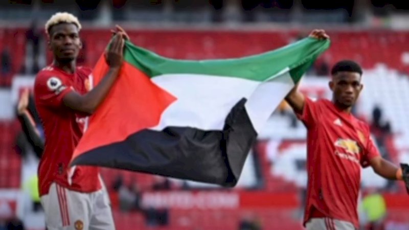 Dua pesepakbola Manchester United, Paul Pogba dan Amad Diallo membawa bendera Palestina. (Foto: Youtube)