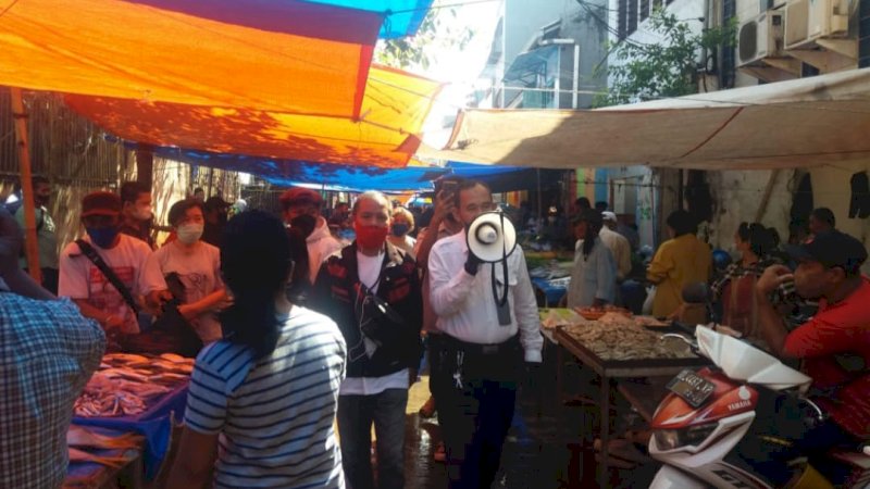 Petugas PD Pasar Makassar Raya mengimbau pedagang dan warga agar patuhi protokol kesehatan (2/6).