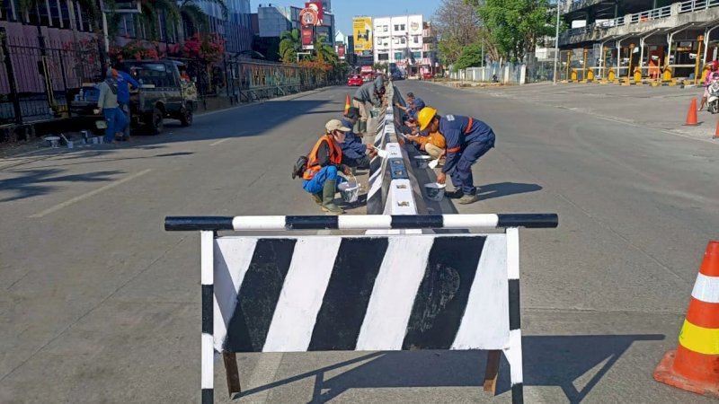 Petugas Pemelihaan Jalan DPU Makassar mengecat trotoar (9/6).