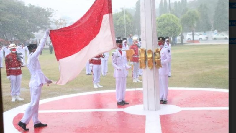 Perjuangan pasukan pengibar bendera pusaka (paskibraka) Kabupaten Bulukumba mengibarkan bendera merah putih di tengah guyuran hujan di Lapangan Pemuda, Selasa (17/8/2021).