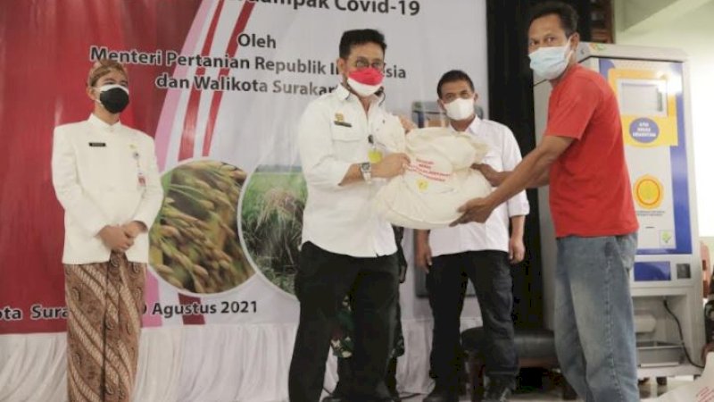 Menteri Pertanian (Mentan), Syahrul Yasin Limpo (SYL), menyerahkan bantuan beras kepada masyarakat. Turut hadir mendampingi Wali Kota Solo, Gibran Rakabuming Raka.