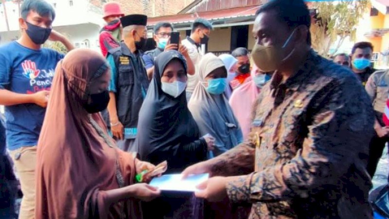 Bupati Wajo, Amran Mahmud (kanan), saat menyerahkan bantuan untuk korban kebakaran di Jalan Jawa, Kelurahan Lapongkoda, Kecamatan Tempe, Kabupaten Wajo, Sulawesi selatan, Jumat sore (27/8/2021).