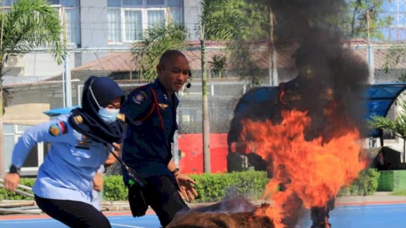 Aksi perempuan berusaha memadamkan api menyala di Rutan Klas I Makassar, Selasa (14/9/2021). Ini adalah pelatihan dan simulasi.