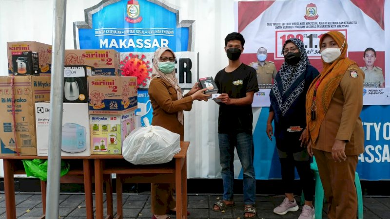 Petugas Vaksinasi di Kelurahan Karampuang Kecamatan Panakukkang saat memberikan doorprize atau hadiah kepada warga yang ikut kegiatan vaksinasi di tingkat RT.(11/10/21).