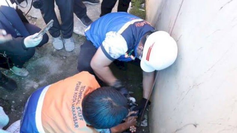 Petugas PDAM Makassar saat memasang meteran air pelanggan (ist) 